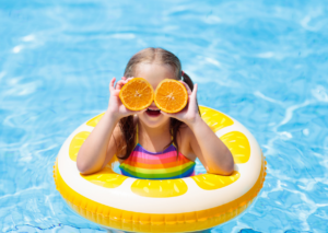 Girl in pool with orange slice eyes