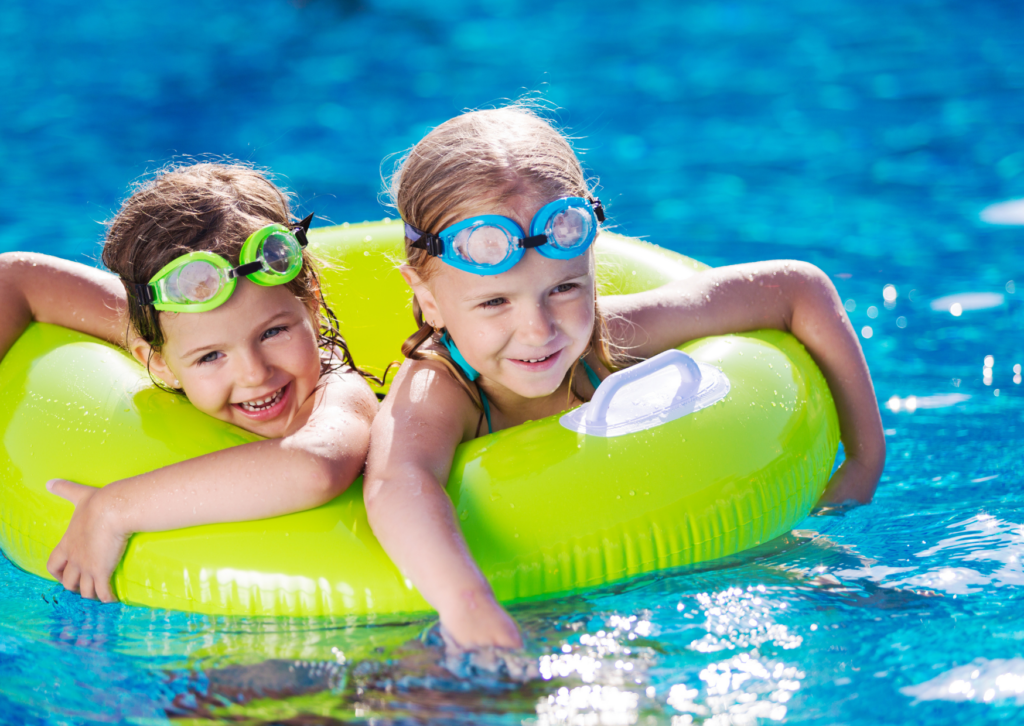 Children playing with inflatable in a swimming pool.