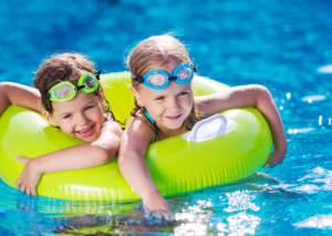 Children playing with inflatable in a swimming pool.
