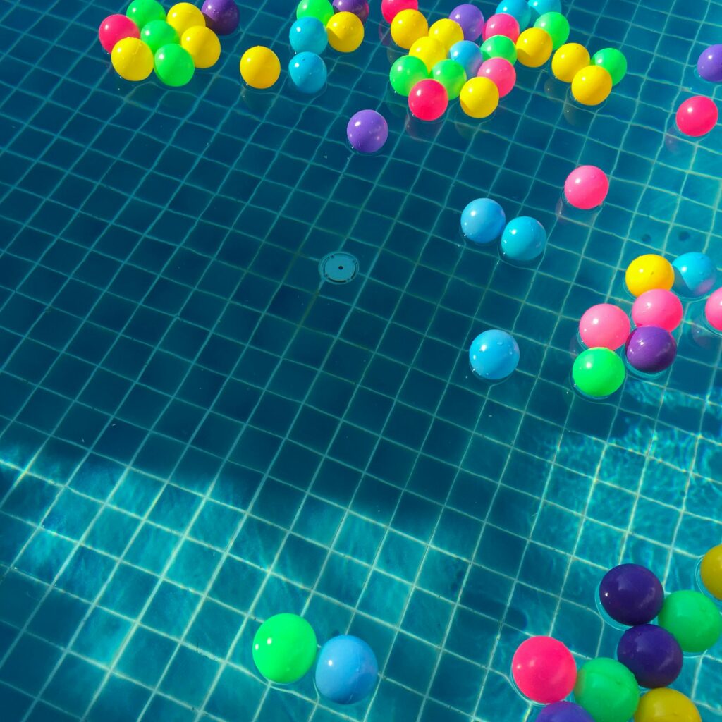 Colourful balls floating in a swimming pool.